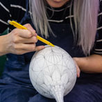 Rhian Malin decorating a mandala bottle in her workshop 2019